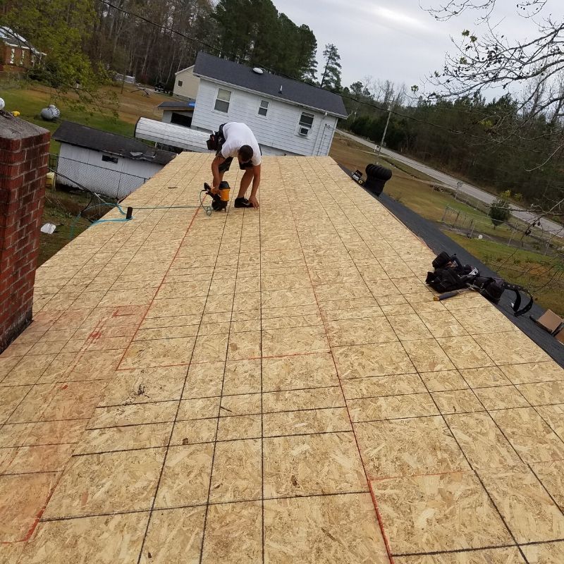 man installing roof deck plywood