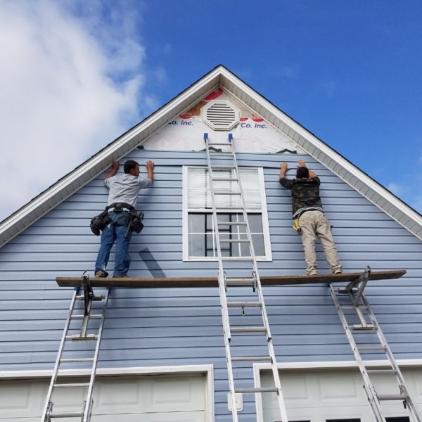 two owners installing vynal siding